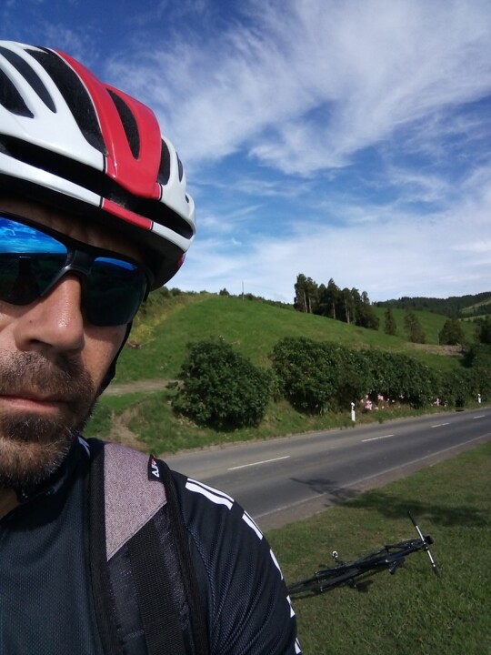 Homem caindo da bicicleta no caminho no campo