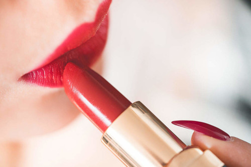 young-woman-applying-red-lipstick_free_stock_photo