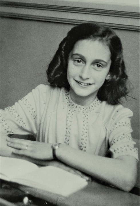 1200px-Anne_Frank_lacht_naar_de_schoolfotograaf_(c