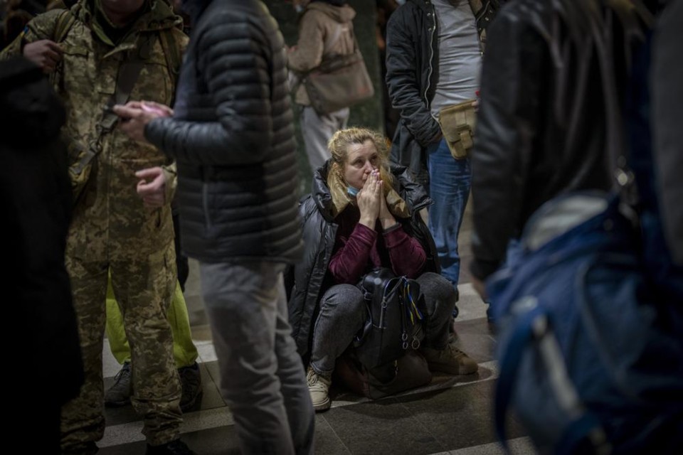 A woman reacts as she waits for a train trying to 