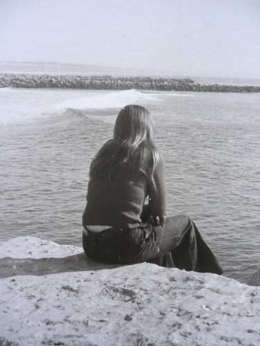 sentada à beira mar