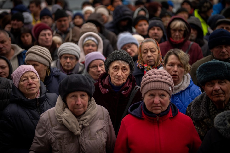 Ukrainians wait for a food distribution organized 