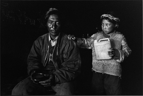 TIBET. 2001. Daughter pouring liquor for her fathe