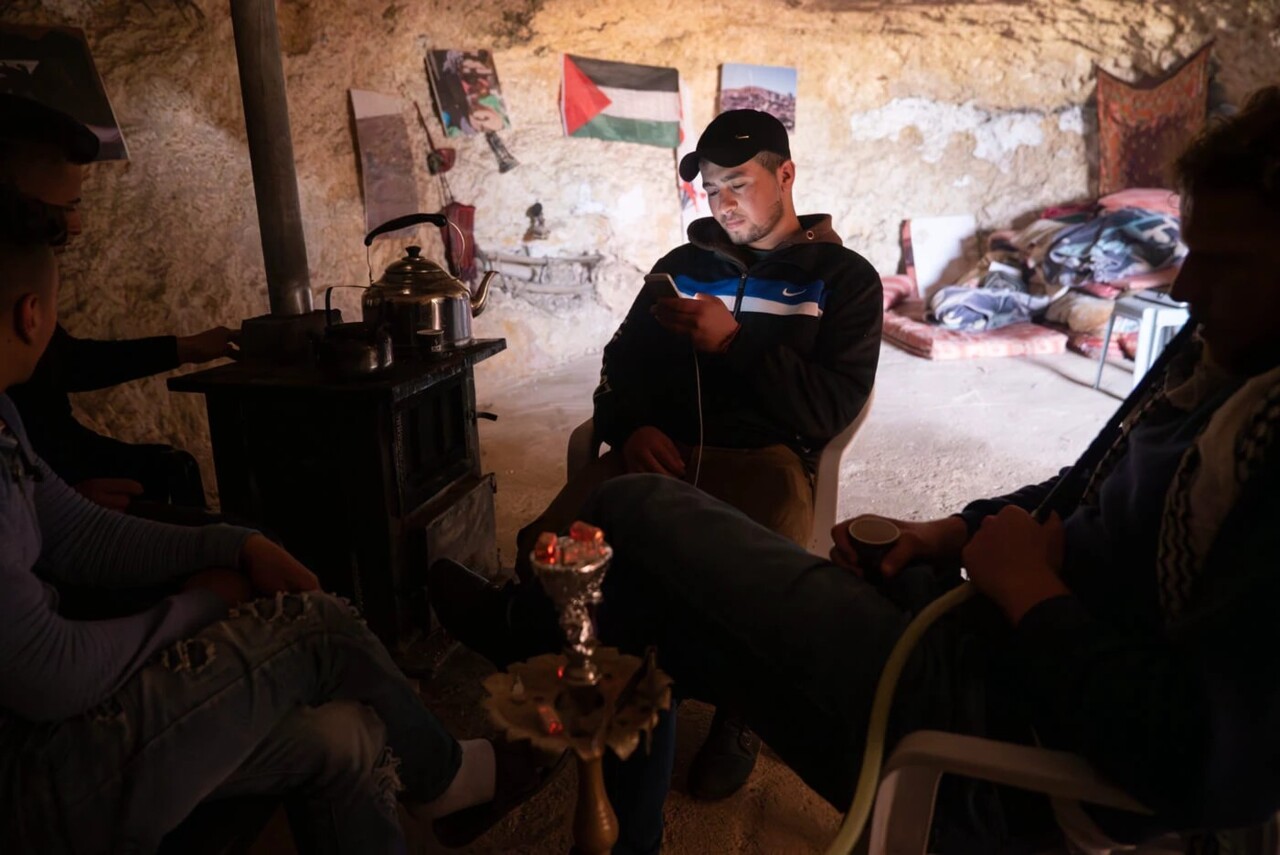 Quem está no telemóvel e de casaco Nike, é Ali Awad. Os jovens tornaram-se alvos frequentes dos ataques de colonos israelitas ao criarem a “Juventude de Sumud”. _ Iuri Barcelos/Agência Pública