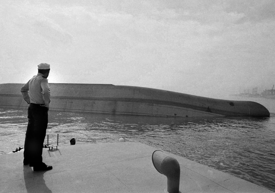 Marinheiro observa os destroços do navio MV Tolla