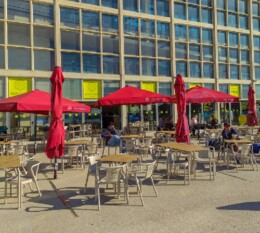 Esplanada com guarda sois vermelhos no Edifício Transparente