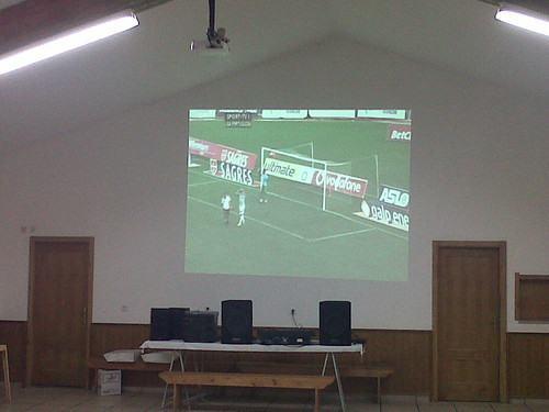 Projector de video do salão a transmitir um jogo de futebol.