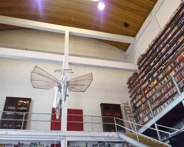 Tecto do interior da livraria Ler Devagar, no Lx Factory. Interior da livraria Ler Devagar, no Lx Factory em Lisboa: Bicicleta presa no tecto e estantes cheias de llivros, primeiro andar da livraria.