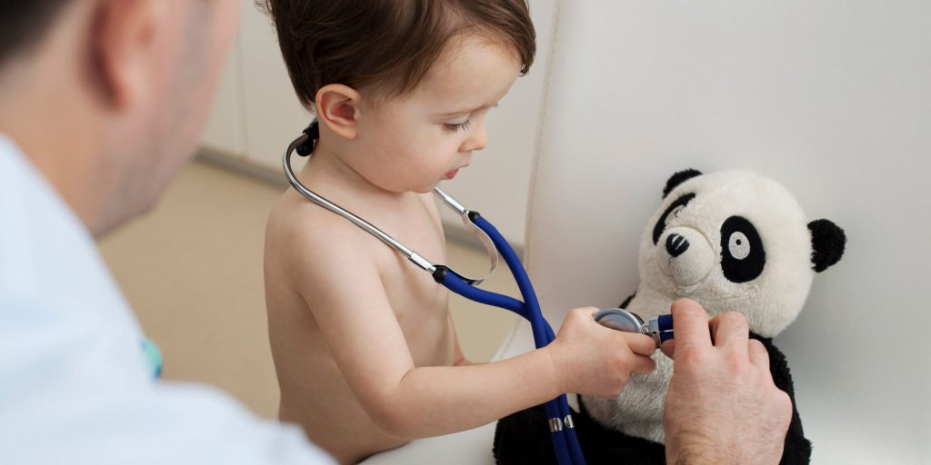 Little boy and doctor using stethoscope on panda toy